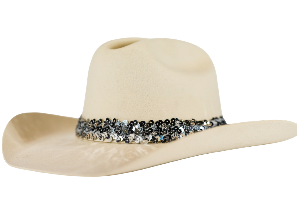 A light beige cowboy hat featuring a decorative band of black and silver sequins around the crown, set against a plain white background.