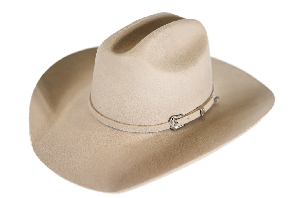 A light beige felt cowboy hat with a matching band and a silver buckle, shown on a plain white background.