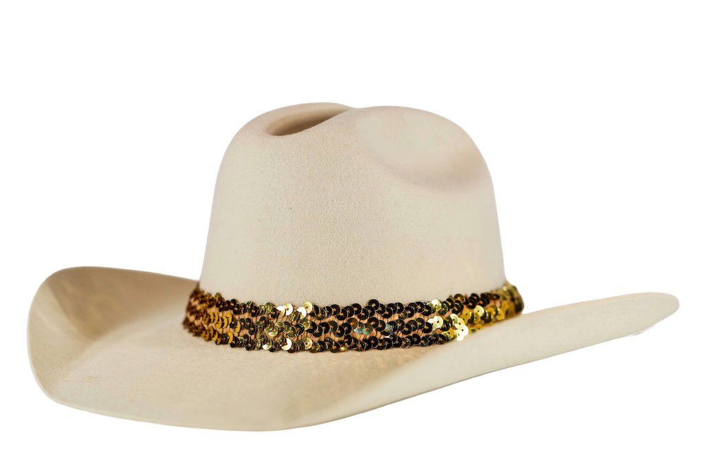 A light beige cowboy hat featuring a wide band of gold and black sequins around the crown, set against a plain white background.